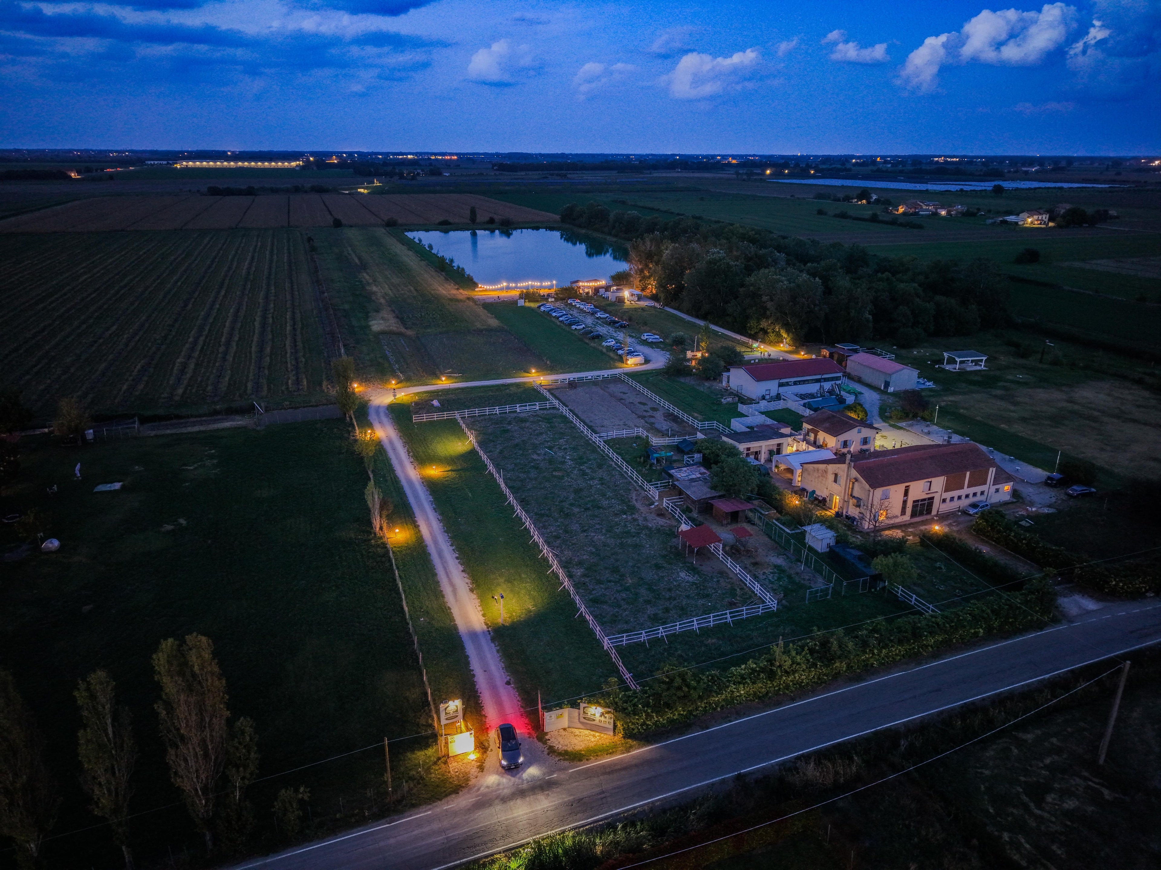 Vista panoramica dall'alto di Podere Masssimo a Parma. Lago, bosco e Fattoria Didattica